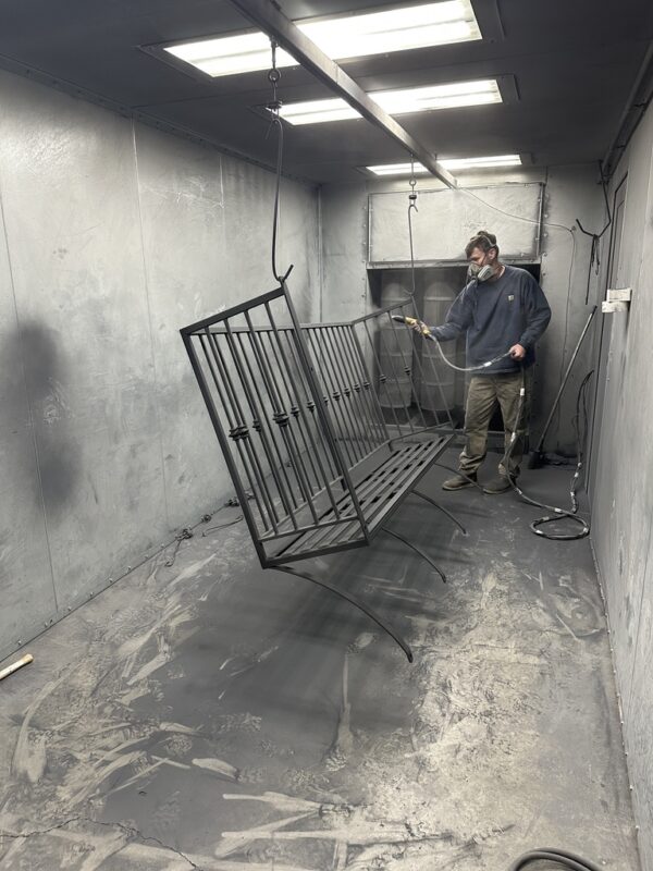Metal handrail being powder coated by Louisville Iron Works